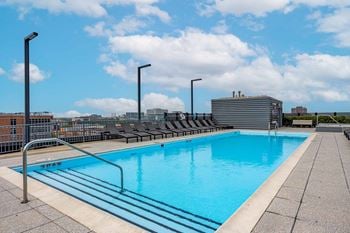 Outdoor rooftop sundeck with pool, hot tub, fire pits, and lounge area